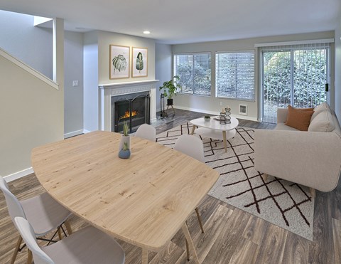 Living and Dining open layout with a fireplace, lots of windows and finished with a small dining set, coffee table and couch.at Edmonds Gateway, Edmonds, 98026